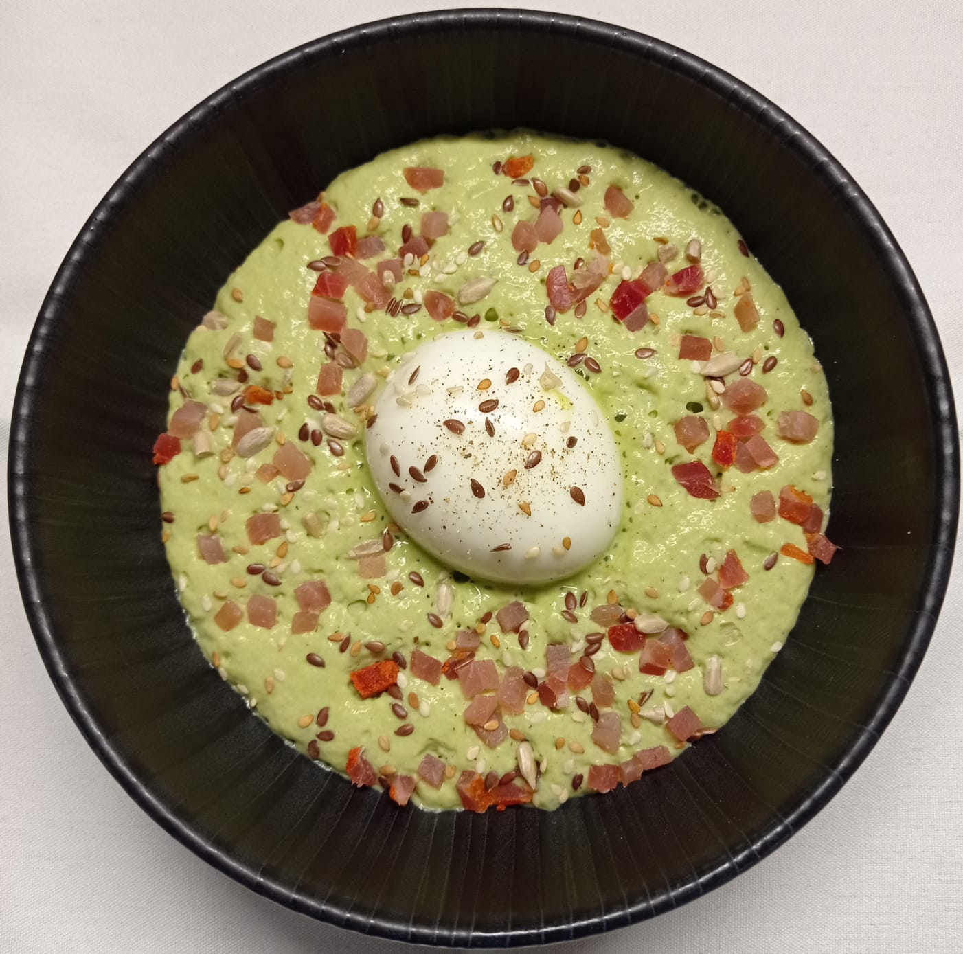 Crémeux de petits -pois à la menthe, oeuf mollet,filet mignon de porc séché et graines torréfiées