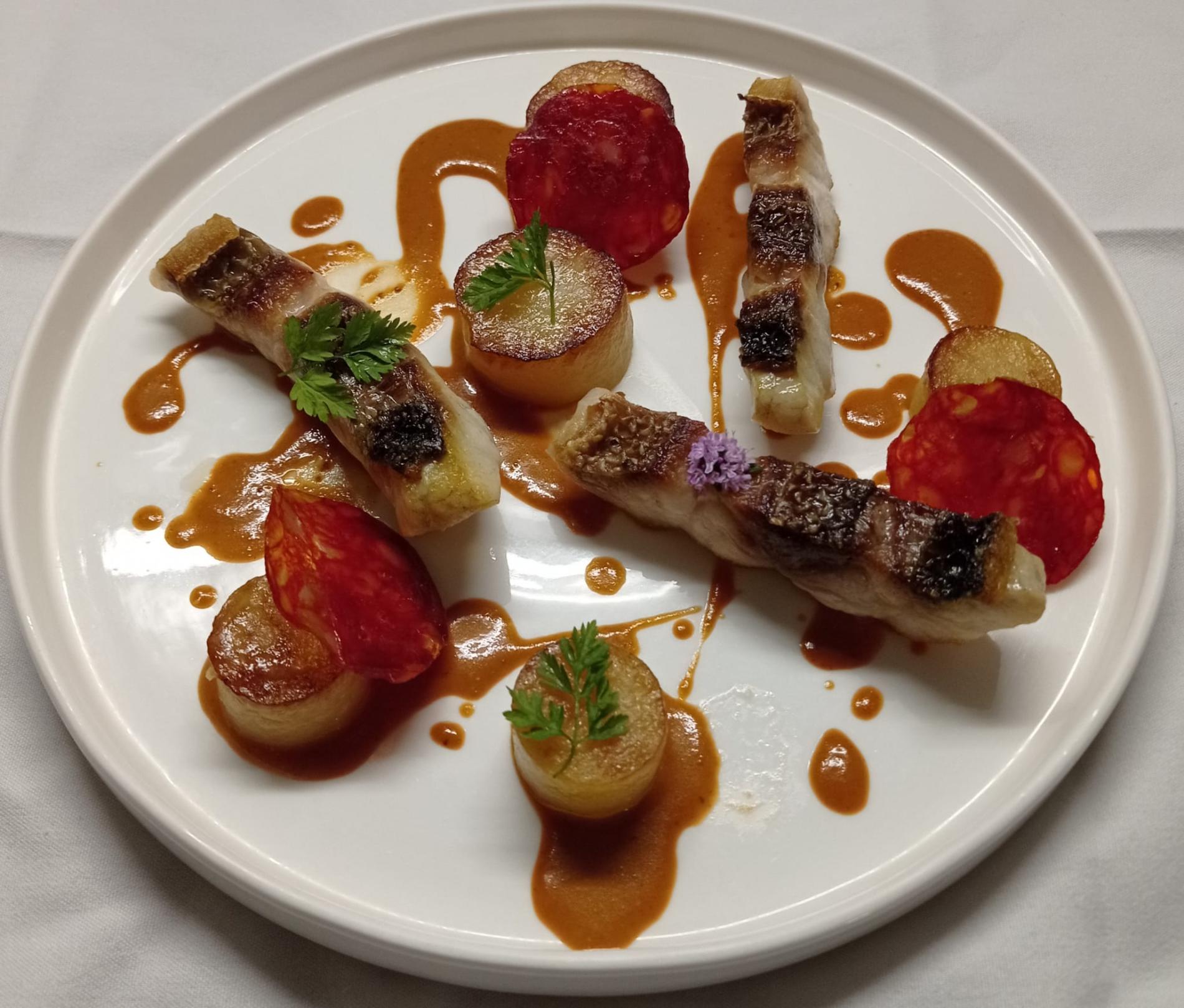 - Poisson retour de la criée,  pommes de terre fondantes et  chorizo, réduction de crustacés à la tomate.